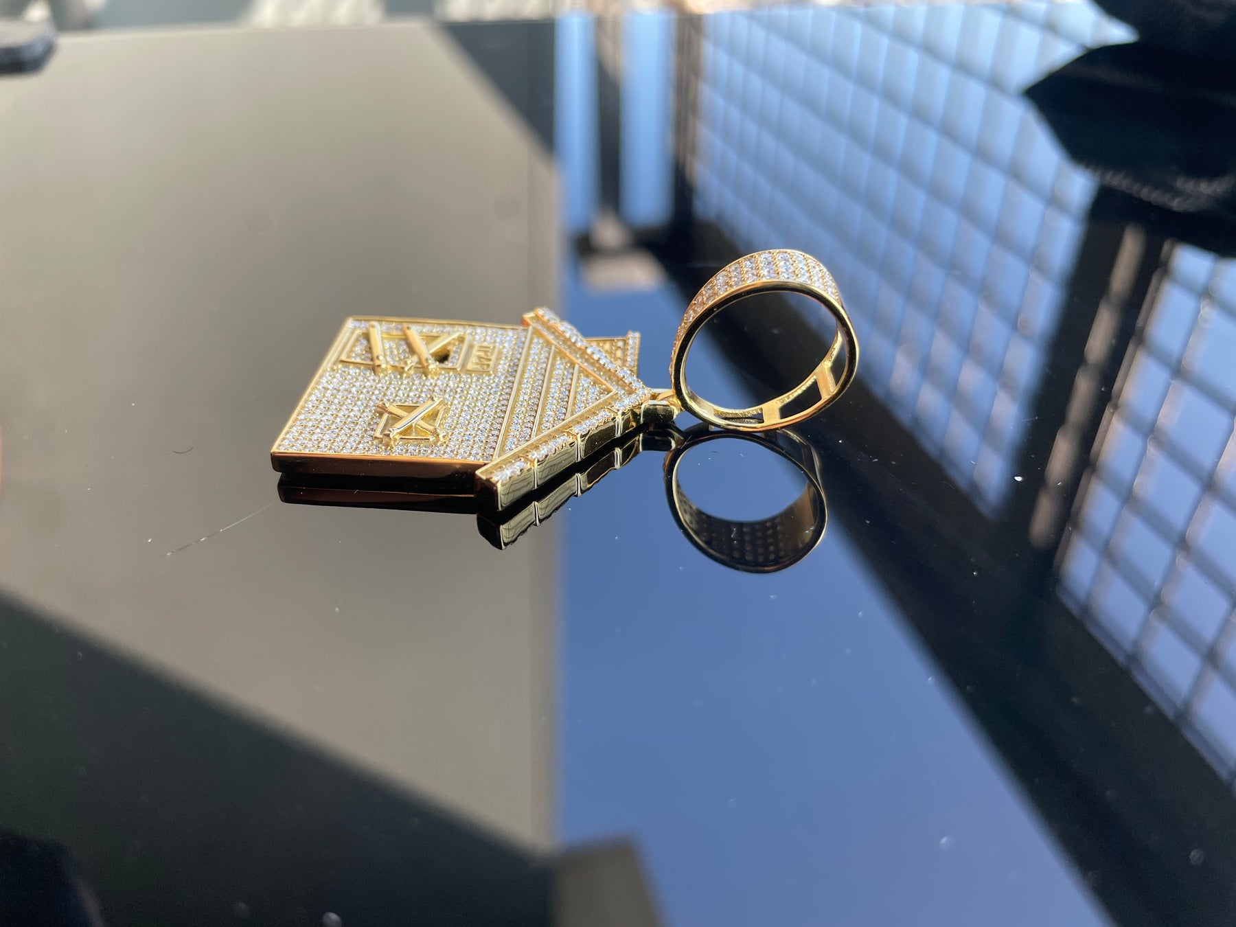 Side view of the moissanite trap house pendant and large gold-plated bail
