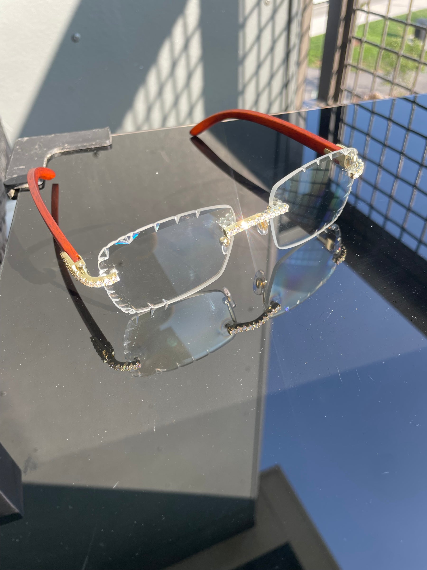 Angled view of clear rimless moissanite glasses with wood-look temples